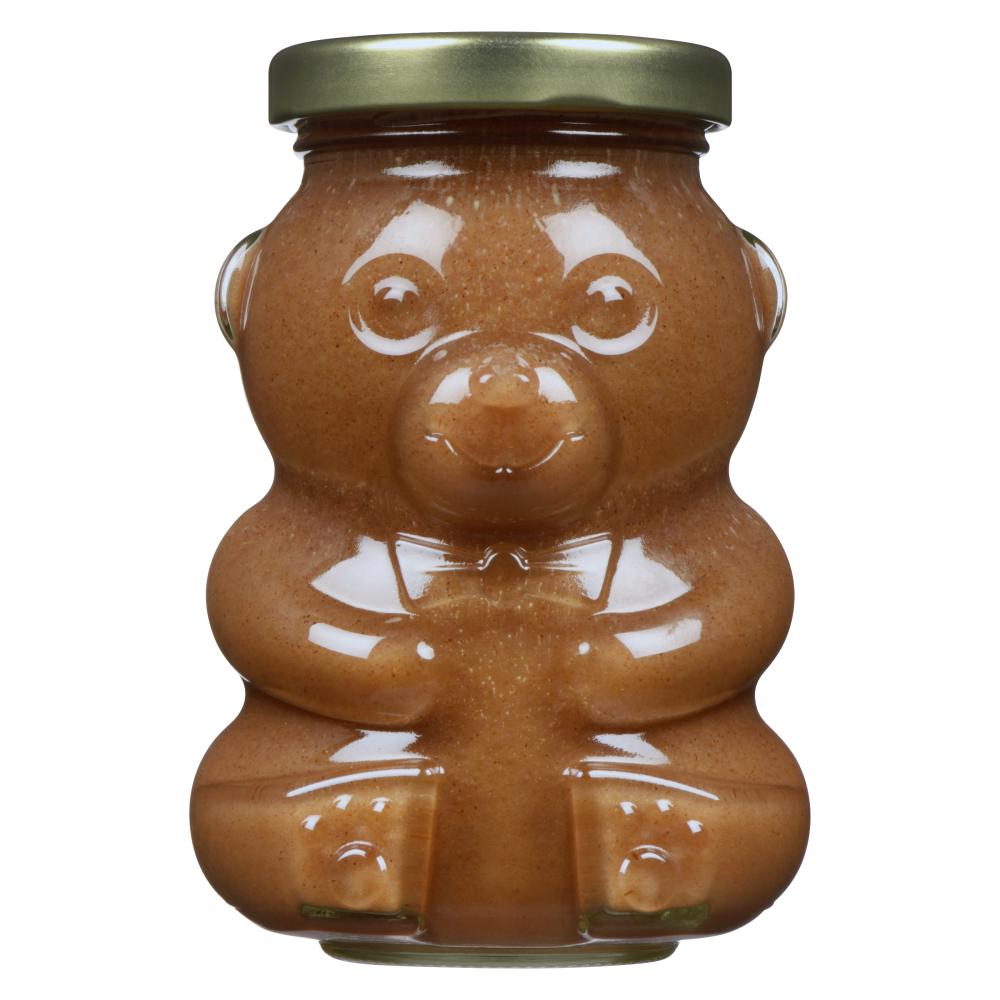 A bear-shaped jar filled with brown spread and a gold lid.