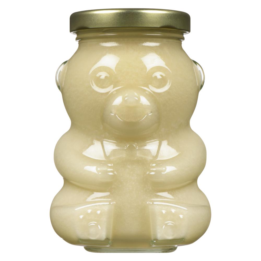 A honey bear-shaped jar with a golden lid filled with creamy substance.