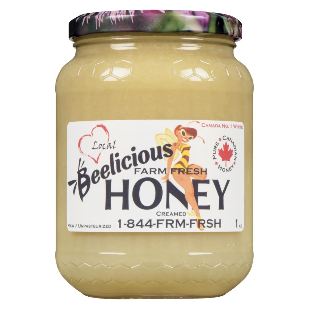 A jar of Beelicious Premium Honey with a purple lid.