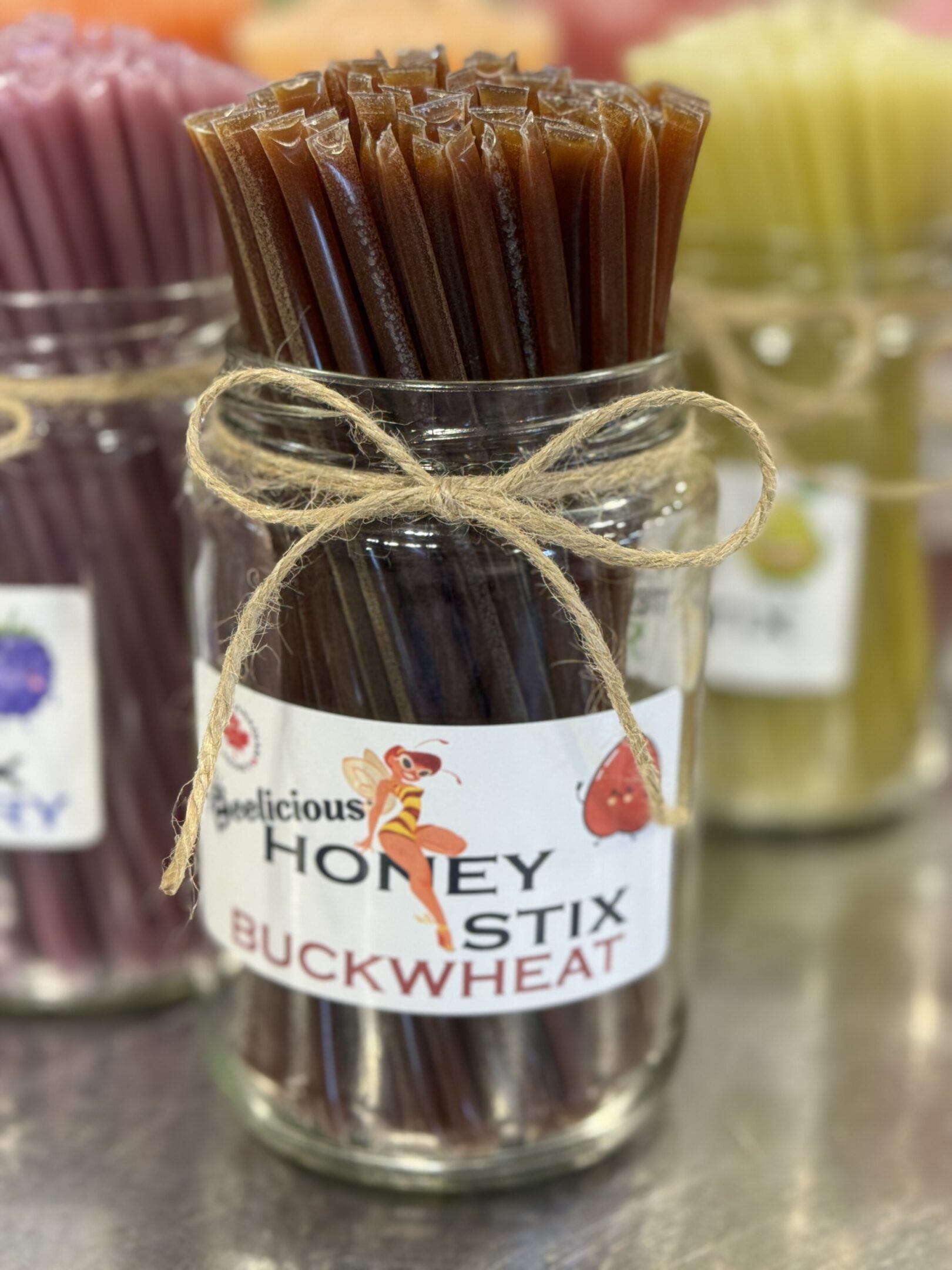 Jar of buckwheat honey sticks tied with rustic twine.