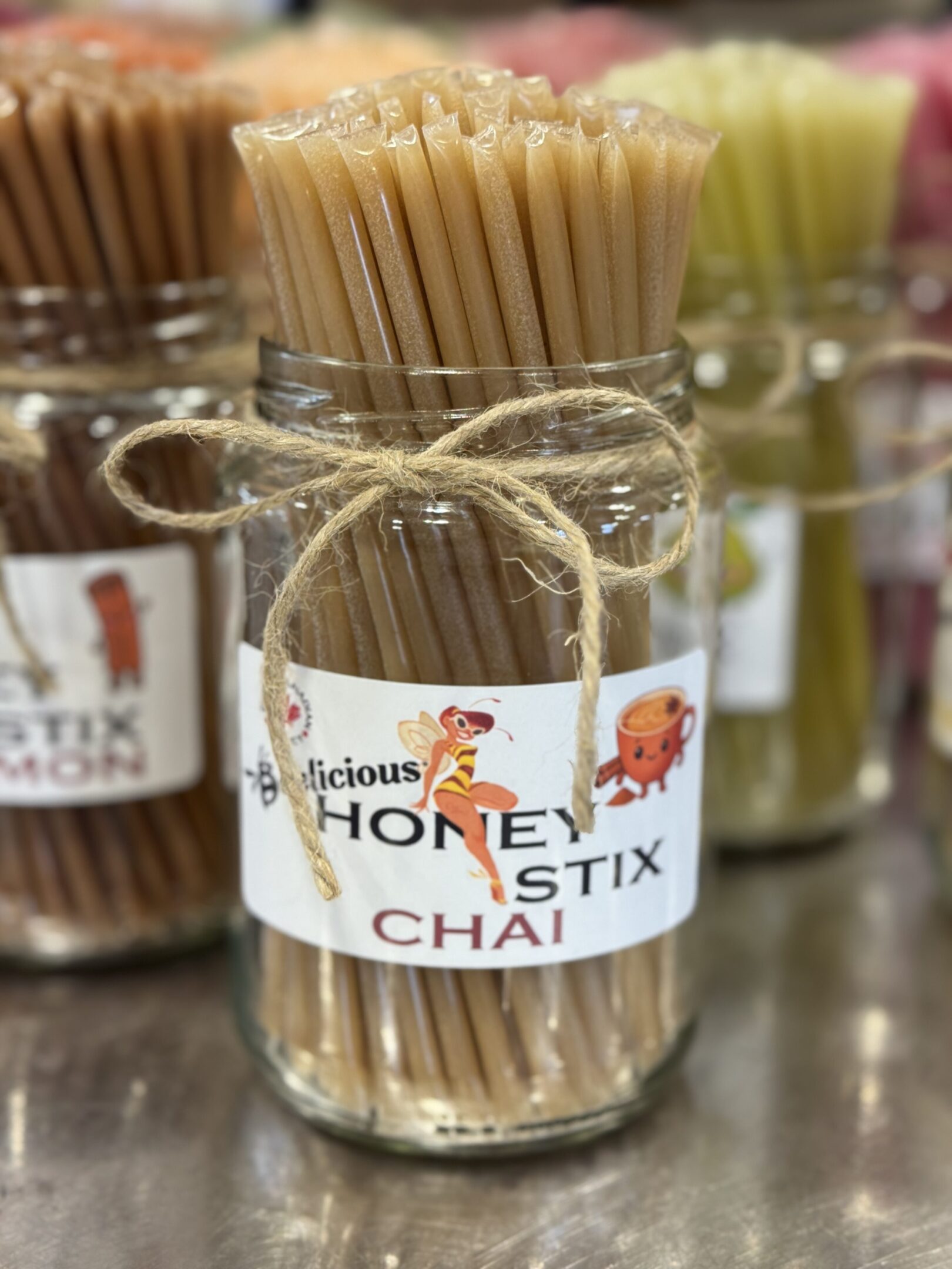 Glass jar filled with honey chai-flavored wooden sticks tied with twine.