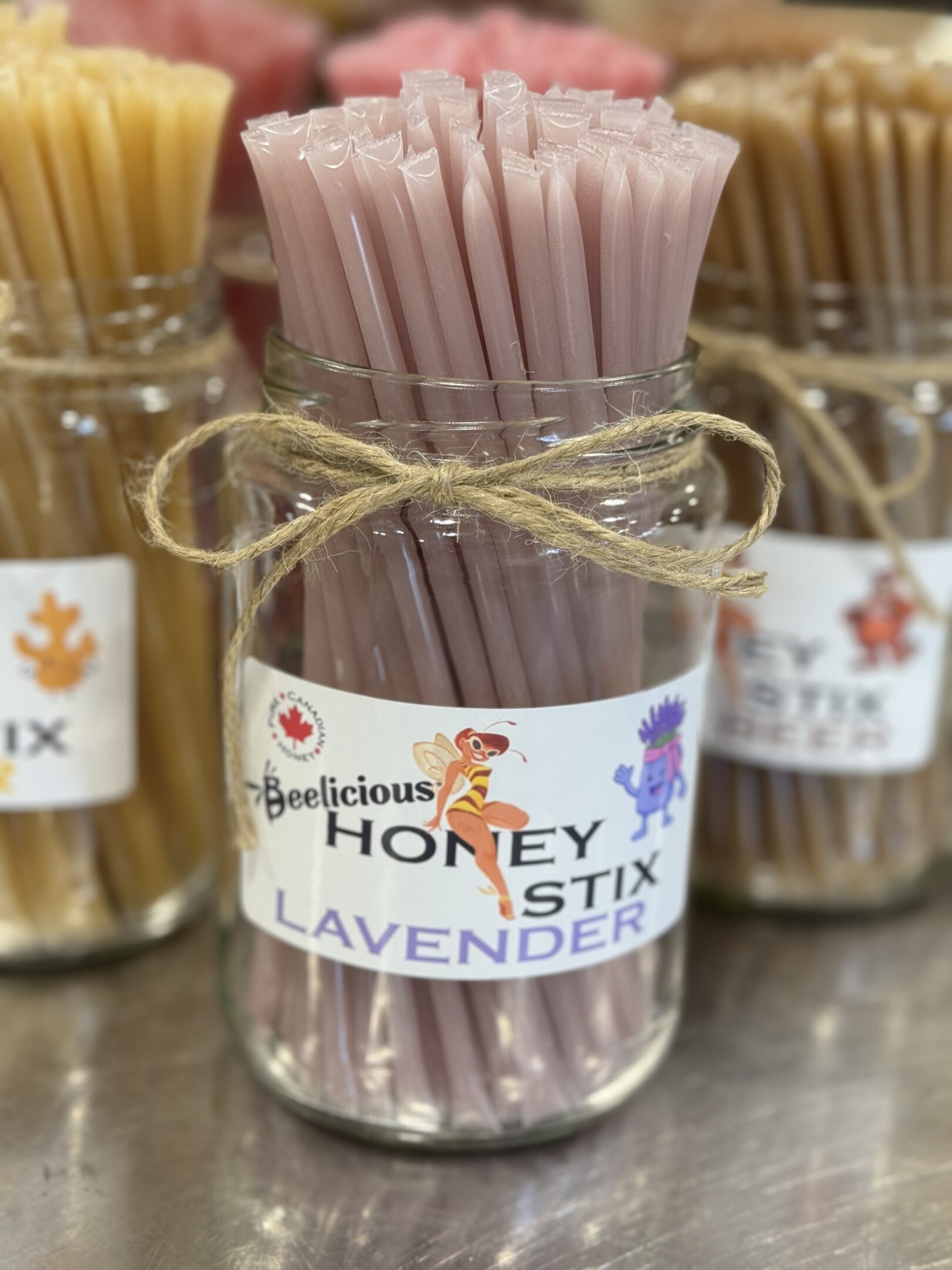 Jar of lavender honey sticks tied with twine.