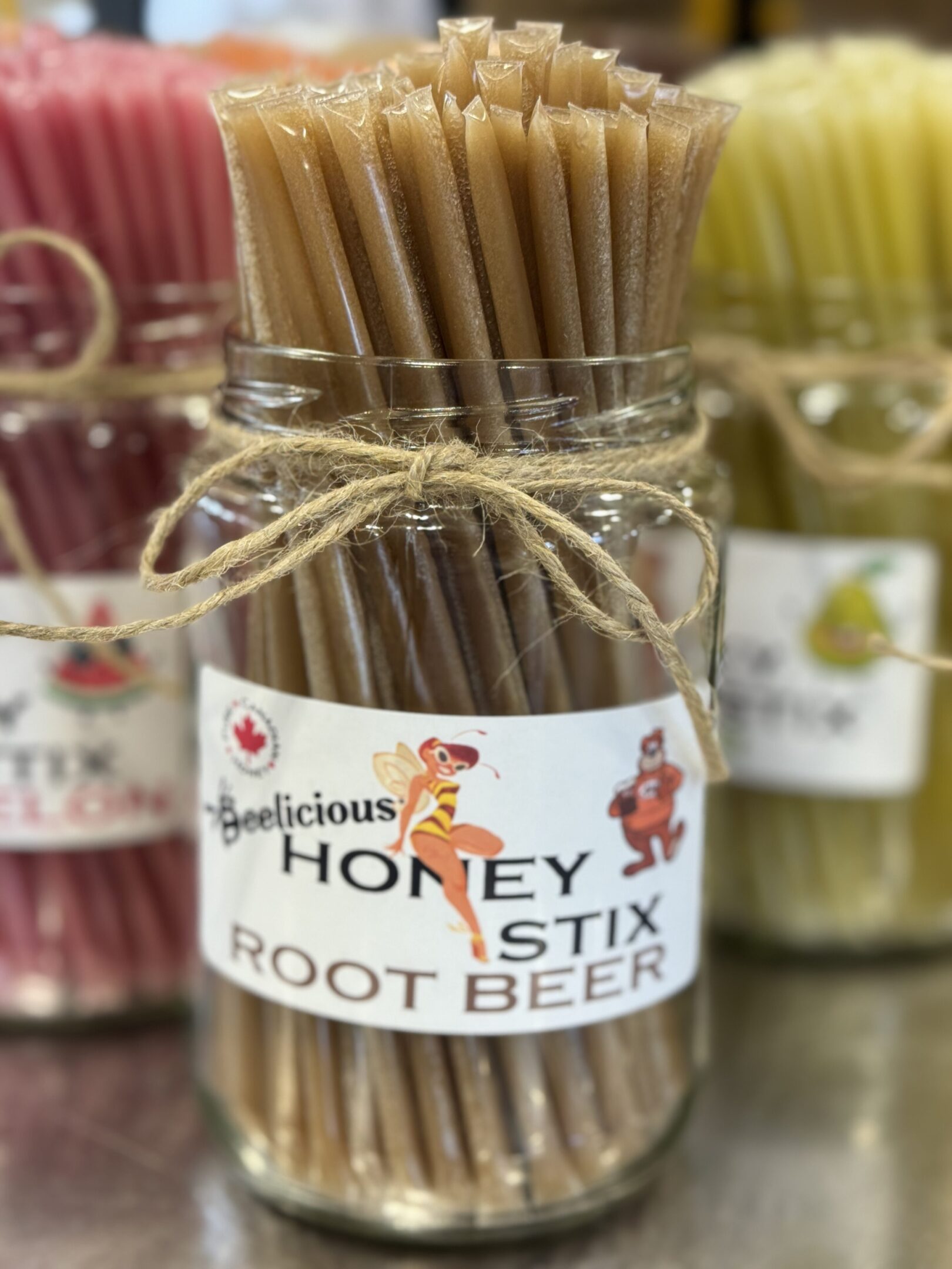 Jar of honey root beer straws tied with twine.