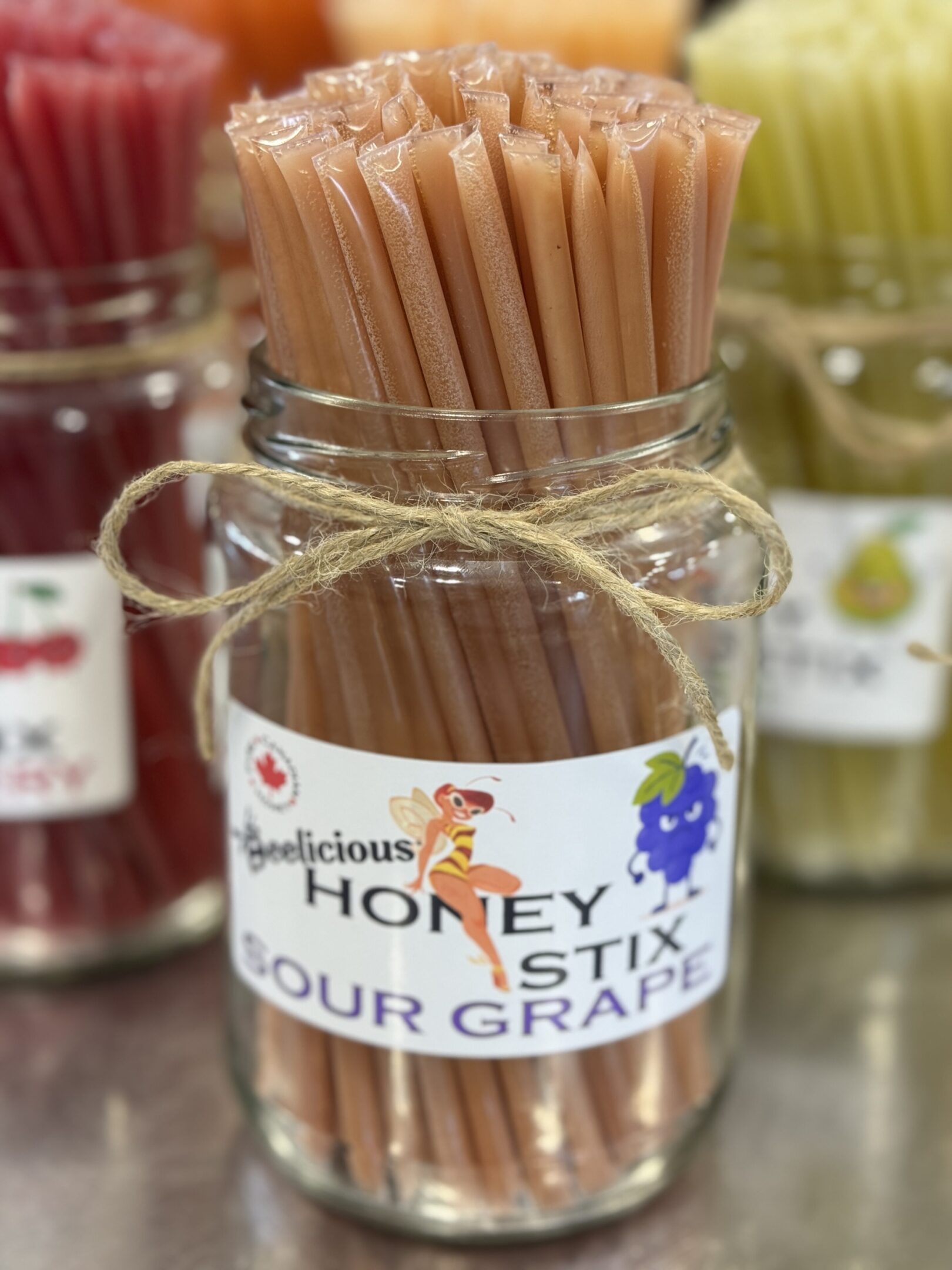 Jar of honey-flavored stir sticks labeled 'Honey Stix for Grabs'.